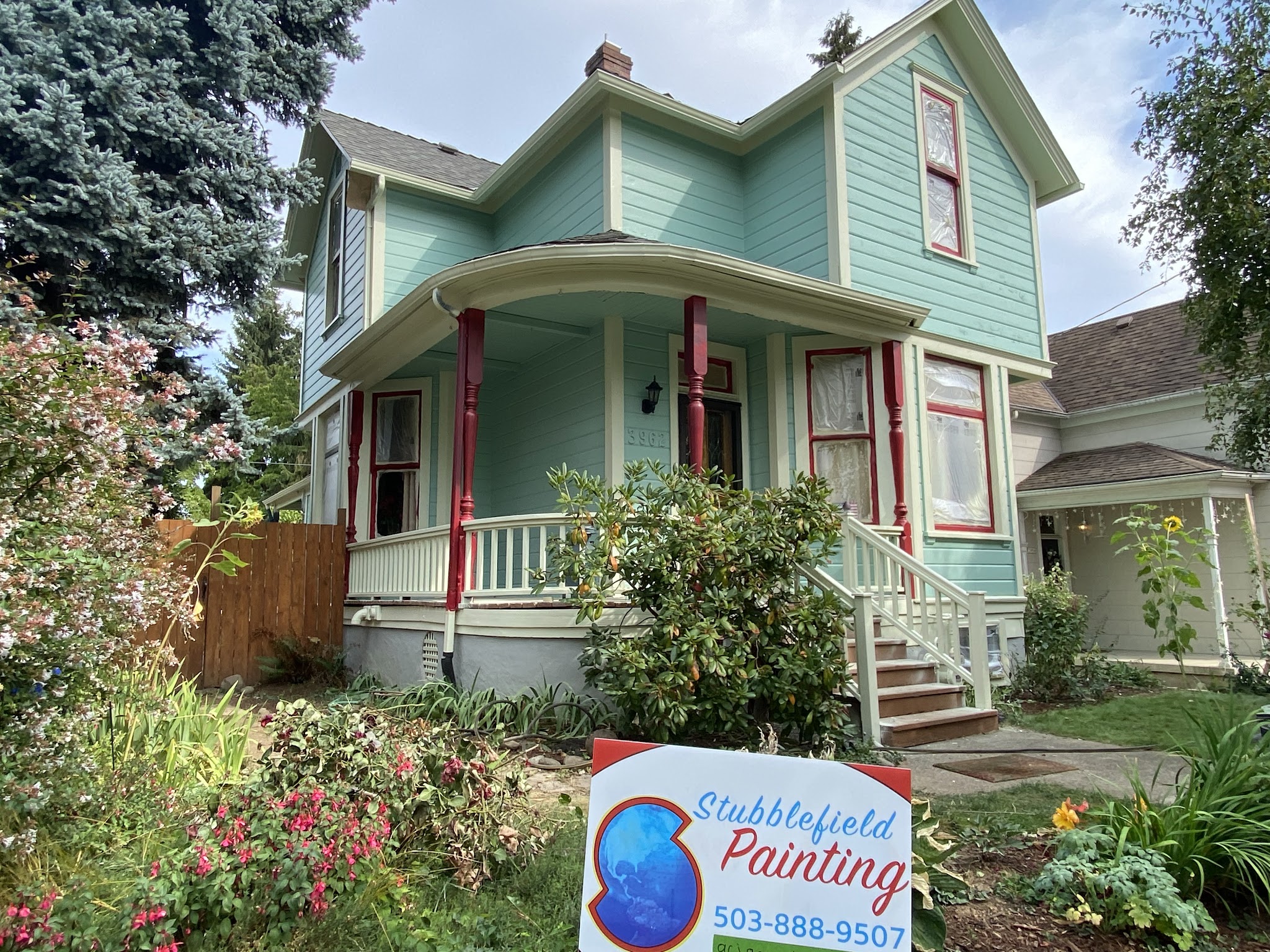 Completed Victorian-style home repaint with red porch trim