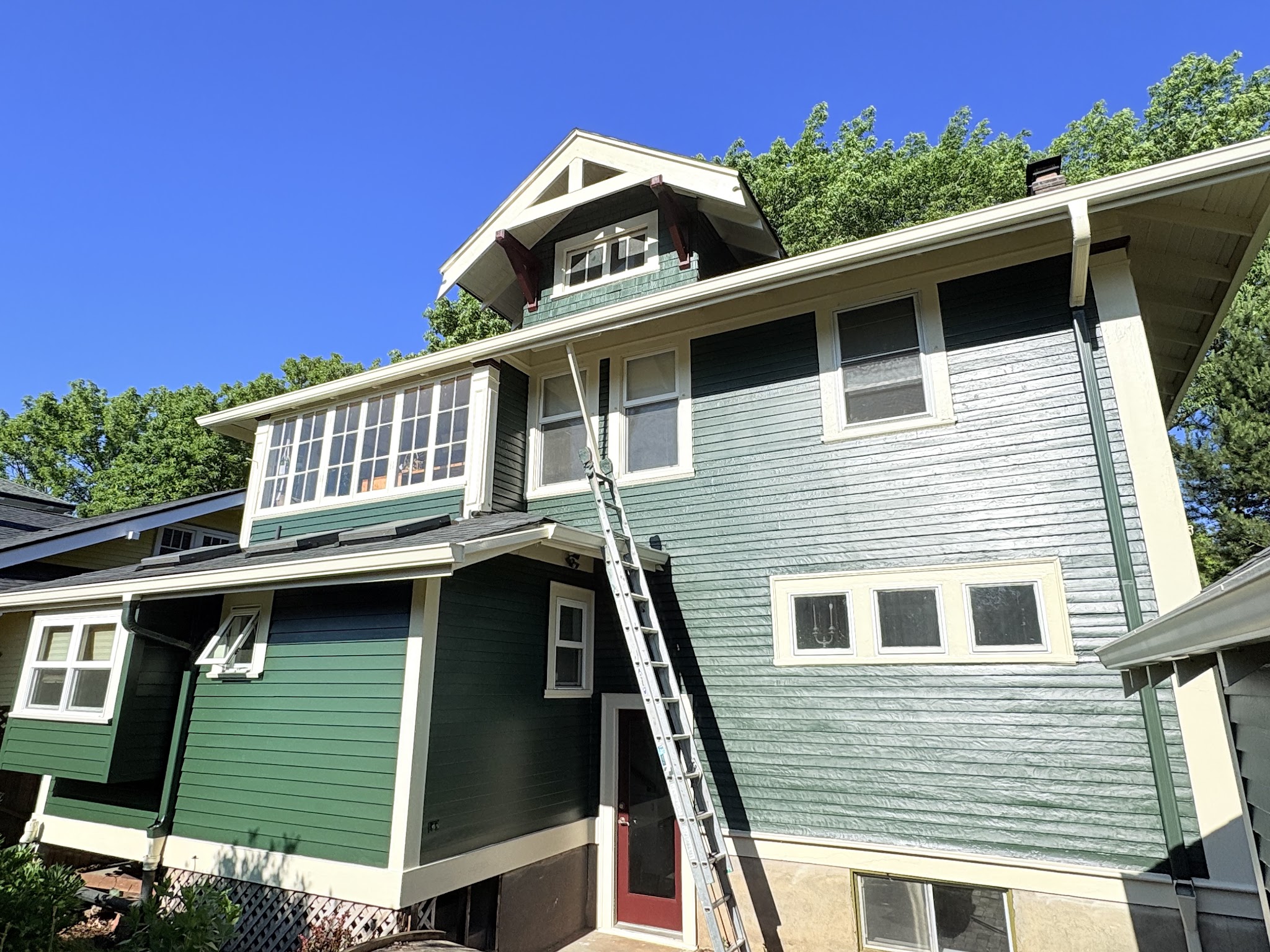 Exterior repaint in progress showing old weathered paint next to fresh paint